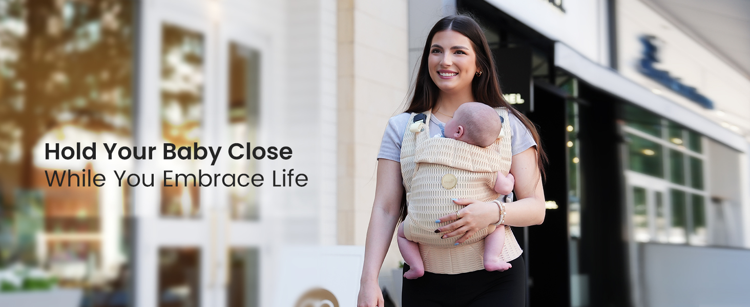 أم تحمل طفلها في حاملة أطفال أرجونوميك مصنوعة من الشبك ثلاثي الأبعاد القابل للتهوية في الهواء الطلق